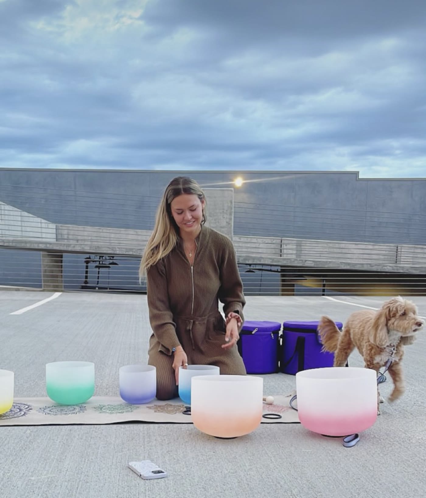 Hanna leading a sound bath with crystal bowls while Joey the dog helps